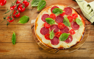 Salami Pizza served on a rustic wooden table.