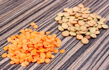 Green and red lentil on wooden background