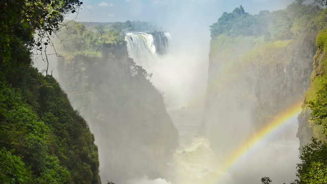 Victoria Falls or Mosi-oa-Tunya waterfall with rainbow in Zimbabwe in HD video footage