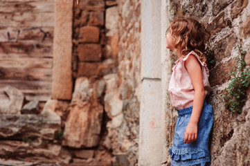 tourist child girl on the walk on streets of Piran, Slovenia in summer