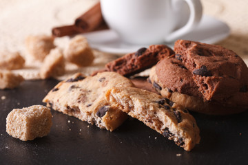 Tasty chocolate chips cookies and a piece of sugar cane macro. horizontal
