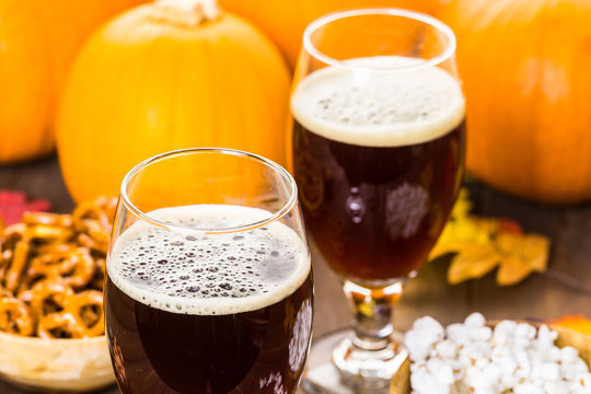 Craft Pumpkin Beer In Beer Glasses With Salty Pretzels And Popcorn