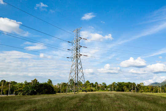 High voltage lines and power pylons in a flat and green agricult