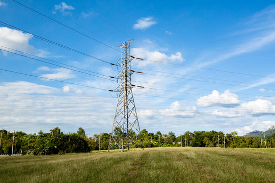 High voltage lines and power pylons in a flat and green agricult