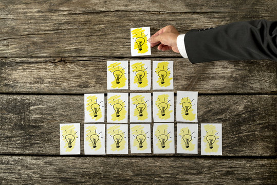 Male hand placing white cards with yellow light bulbs in a form