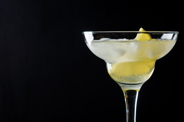 Cocktail margarita with lemon on black background