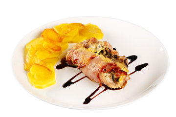 Chicken and fried potatoes with balsamic sauce on a white plate