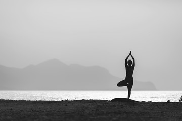 Woman meditating in yoga pose silhouette