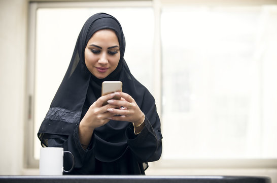 beautiful young arabian woman texting
