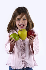 Girl, aged four, with some apples in his hands, looking at the camera smiling