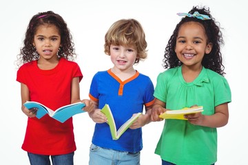 Three kids standing with books in their hands