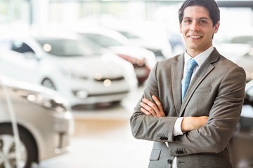 Smiling businessman standing with arms crossed 