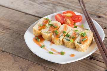 Eggs roll with carrot and onion on wood table. Selective focus.