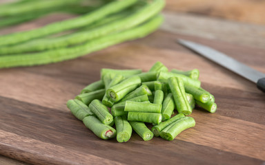 Cut of long bean on wood cutting board.