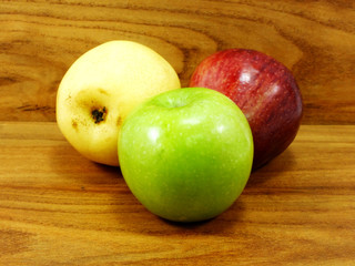 green apple yellow chinese pear and red apple on wooden background