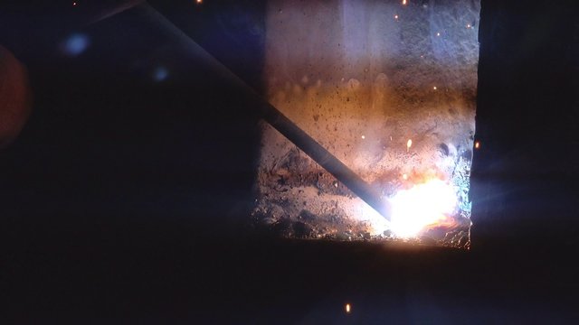 Close up macro footage of shielded metal arc welding in workshop, male welder using electrode to melt the metal at the welding point.