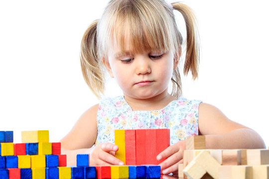 Cute three year old playing with wood blocks.