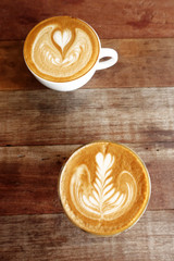 cup of latte art coffee on wooden background