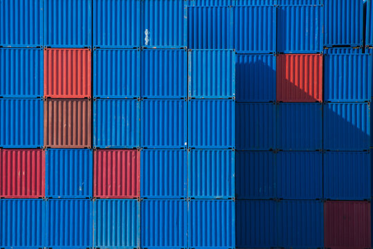 Full frame close up of stacked blue and red shipping containers in a port