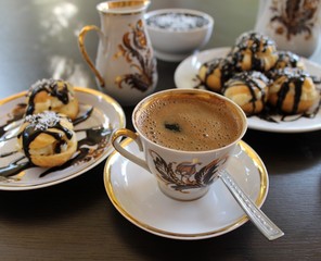 Profiteroles choux pastry, baked in the oven filling and custard poured chocolate and coffee
