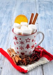 chocolate or cocoa drink with marshmallows and cinnamon in a Christmas cup with cinnamon on gray wooden background