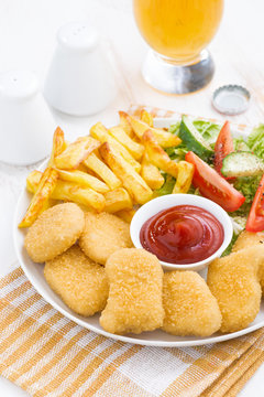 fast food - chicken nuggets, french fries and vegetable salad