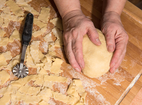 Woman kneading dough on a table in the kitchen