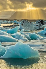 Papier Peint photo autocollant Glaciers Fonte des icebergs au lagon glaciaire de Jokulsarlon au coucher du soleil