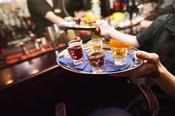 Several shot glasses on silver tray 