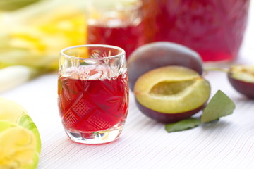 Glasses of plum alcohol with fresh plums