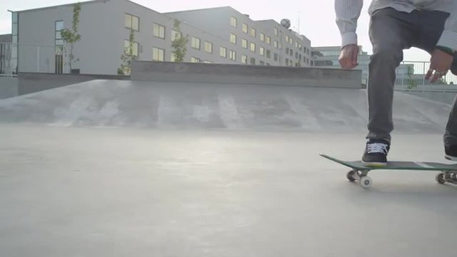 SLOW MOTION CLOSE UP: Skateboarder riding the ramp in skatepark