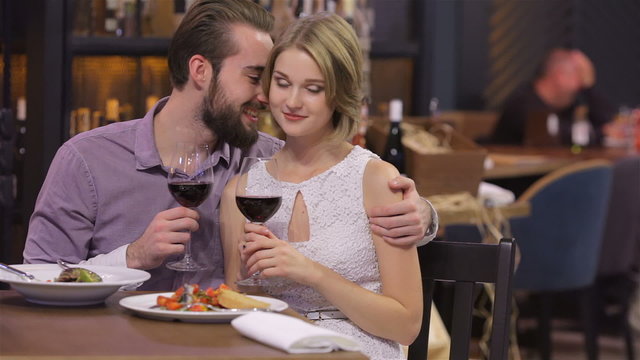 Engaged couple with wine glasses in restaurant