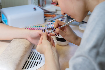 Obraz na płótnie Canvas manicurist at work, painting nails in nail salon, UV lap of quic