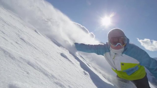 SLOW MOTION: Snowboarder boarding in fresh snow