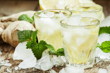 refreshing cold drink with ginger, lemon, ice and mint, selectiv