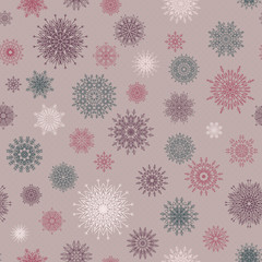 Christmas seamless pattern from red andblue snowflakes on a pastel background.