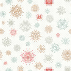 Christmas seamless pattern from red and blue snowflakes on a pastel background.