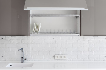 interior design of clean modern white and black kitchen with stainless steel equipment