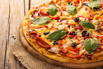 Delicious pizza served on wooden table