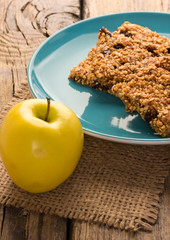 Granola bars with apple on wooden table