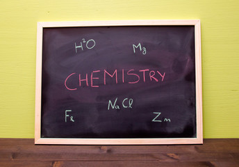 Blackboard with chemistry lesson on green wall