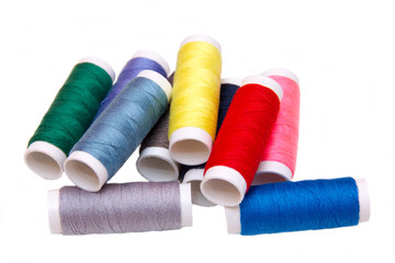 Sewing thread in different colors on white background