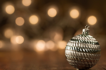 beautiful Christmas ball on the defocused background of yellow lights. Festive decoration.