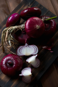 Closeup of red onions on a dark rustic wooden background