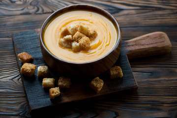 Wooden bowl with pumpkin cream-soup, studio shot