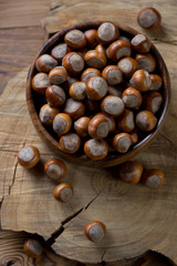 Above view of a wooden bowl full of hazelnuts, studio shot