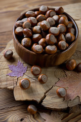 Wooden bowl with hazelnuts, selective focus, studio shot