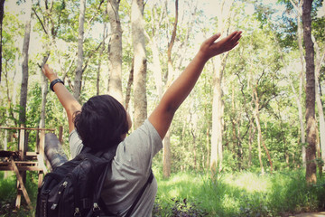 Woman tourist with a backpack in the forest