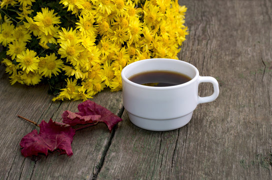 bouquet of yellow flowers, red leaf and coffee