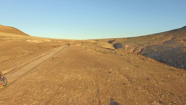 AERIAL: Flying over extreme bikers bicycling through the desert valley